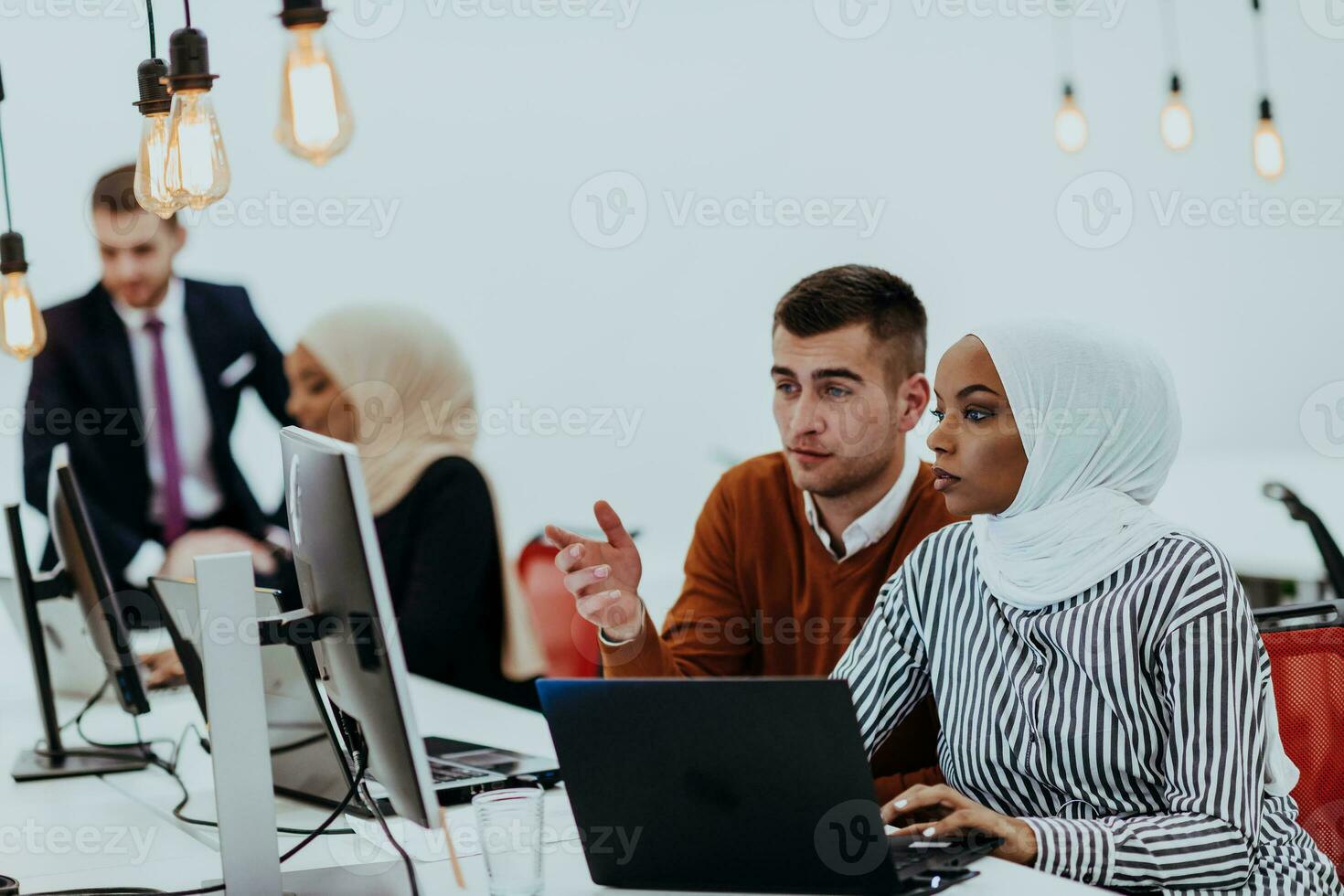 Multiethnic group of employees working in a marketing company. A group of colleagues is working on a project in modern offices photo
