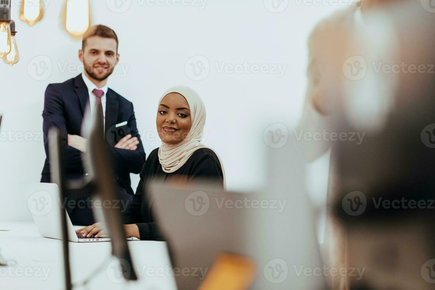 Portrait of a formal businessman and young African American businesswoman posing with their team in a modern startup office. Marketing concept. Multi-ethnic society. photo