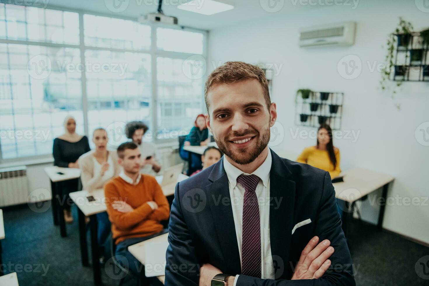 A group of diverse young men and women sit in a modern classroom and listen to a lecture on business training photo