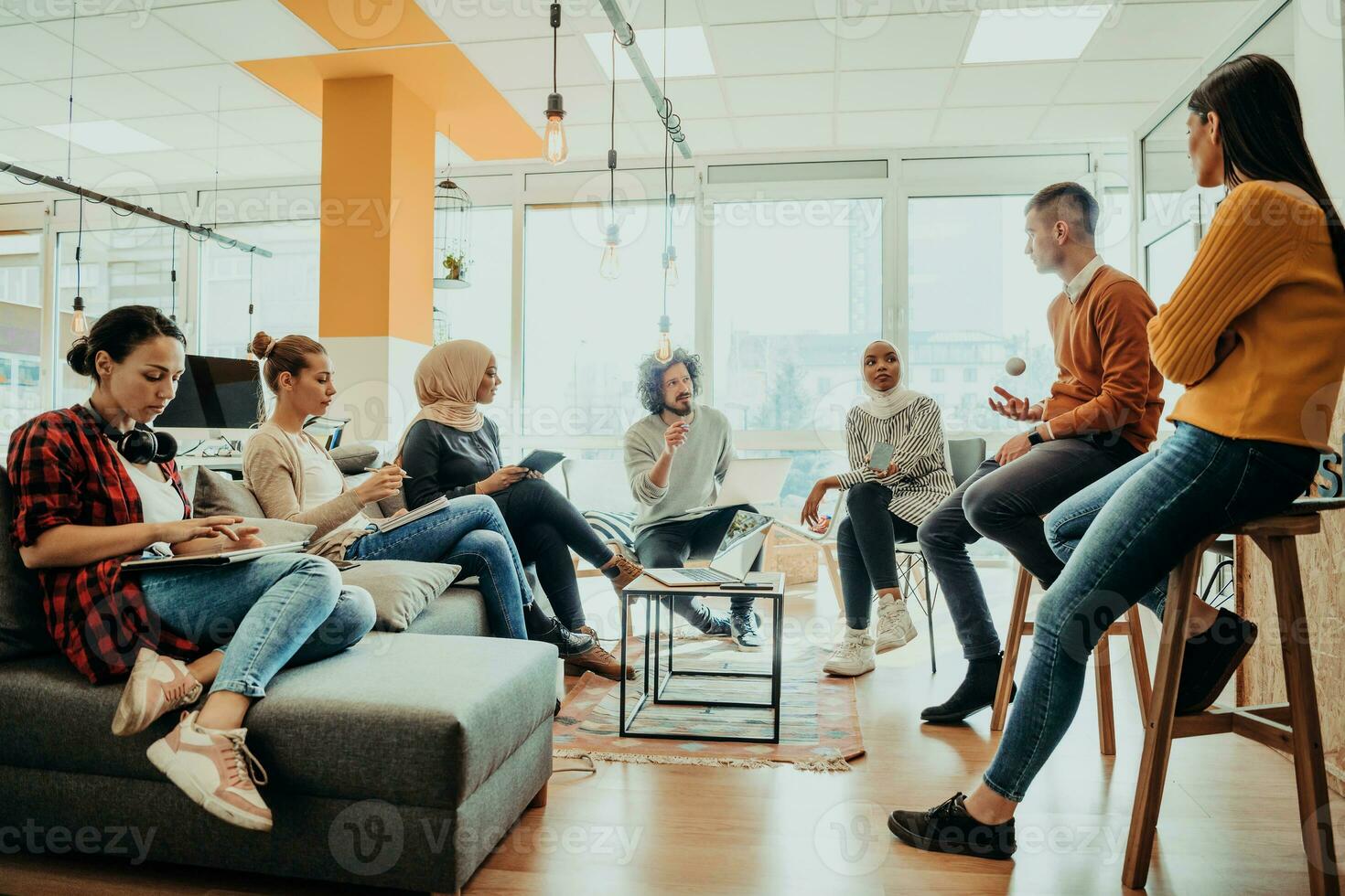 Young designer giving some new ideas about project to his partners in conference room. Business people discussing over new business project in office. photo