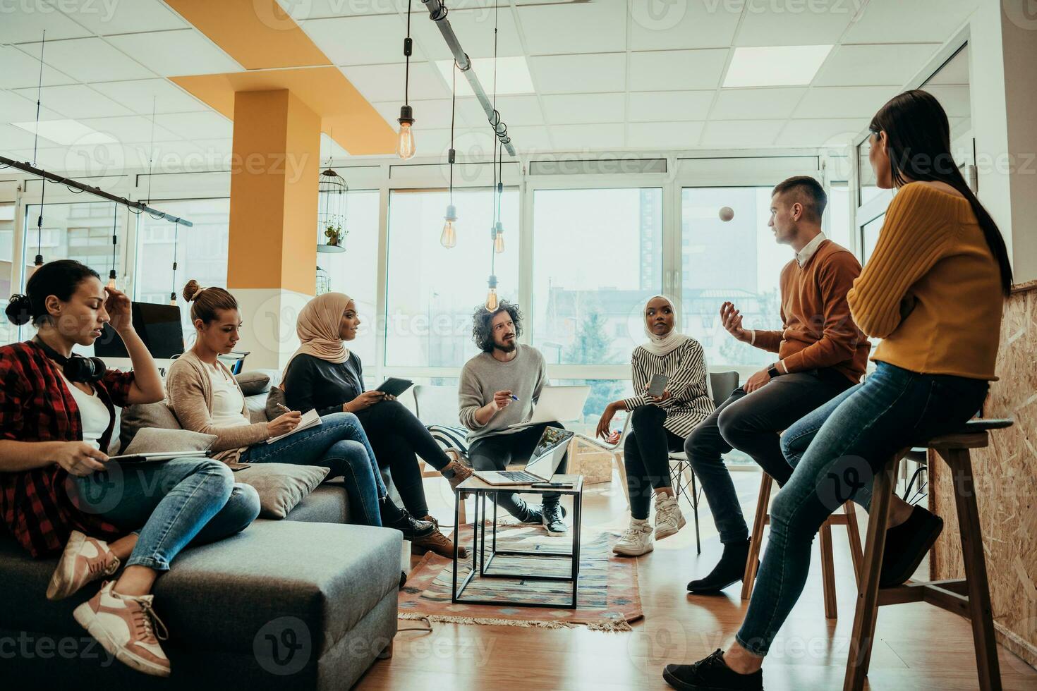 Young designer giving some new ideas about project to his partners in conference room. Business people discussing over new business project in office. photo