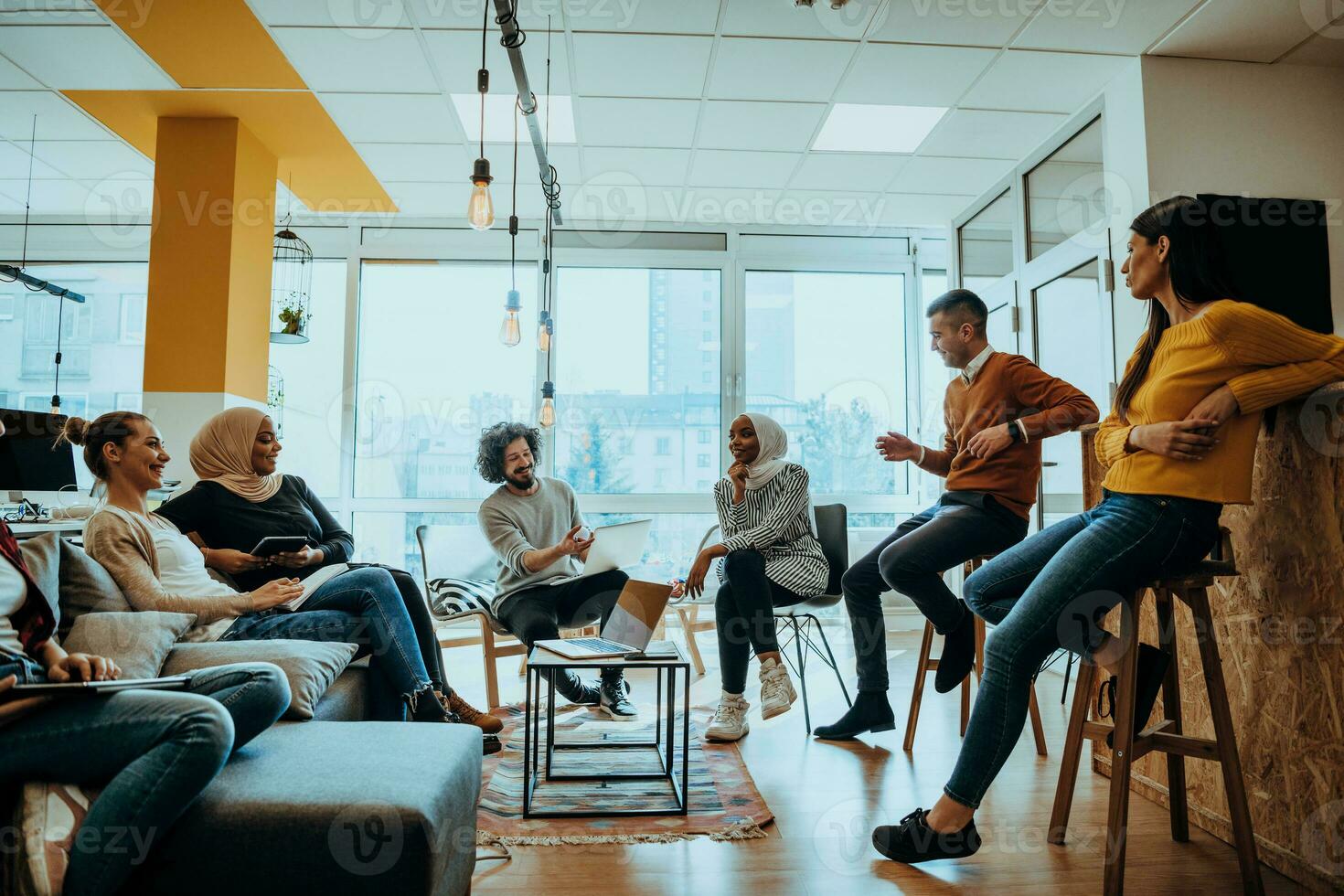 Young designer giving some new ideas about project to his partners in conference room. Business people discussing over new business project in office. photo