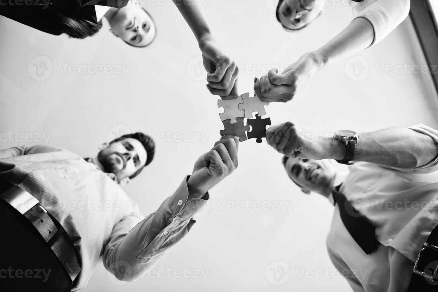 Group of business people assembling jigsaw puzzle photo