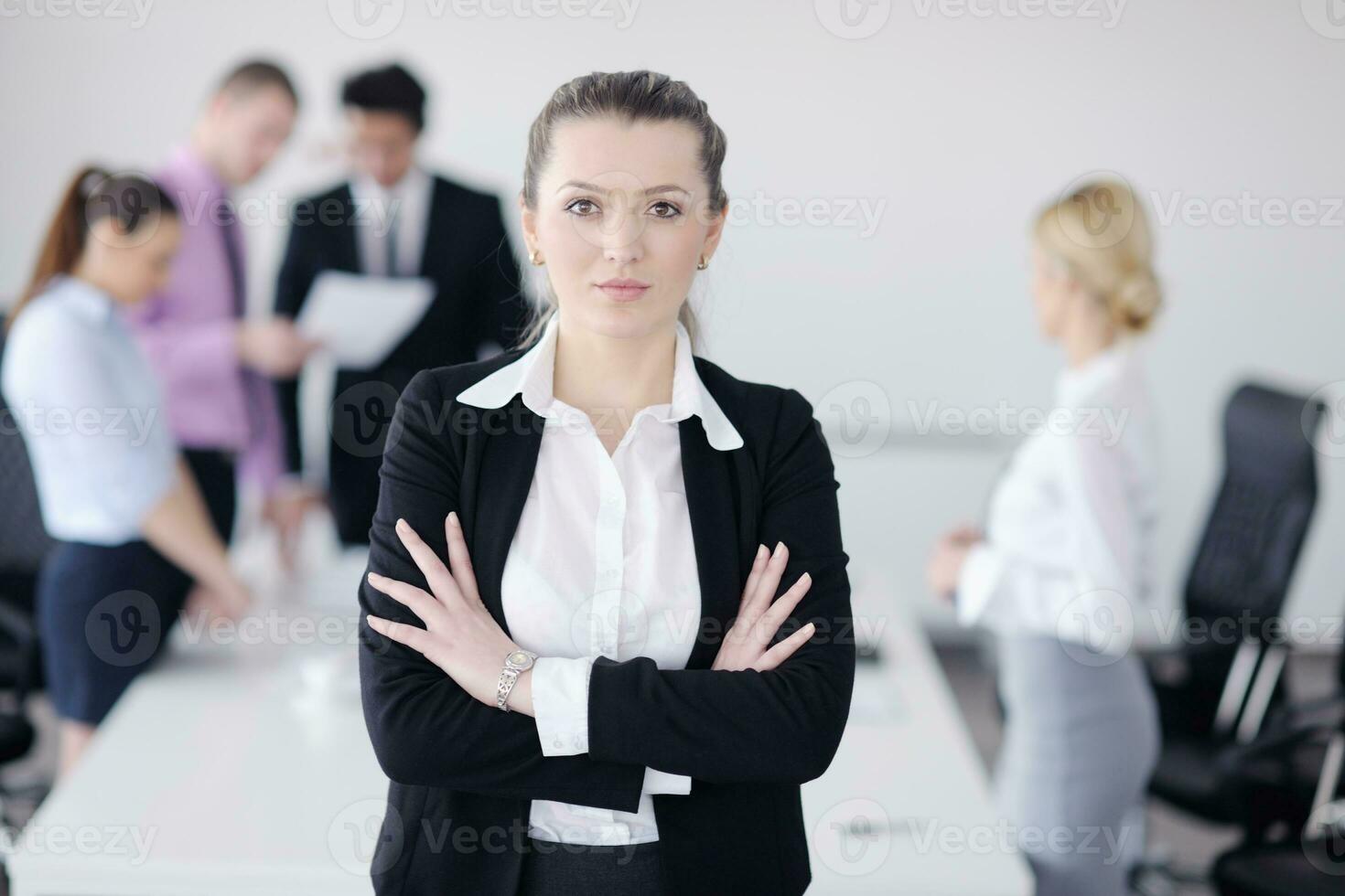 business woman standing with her staff in background photo