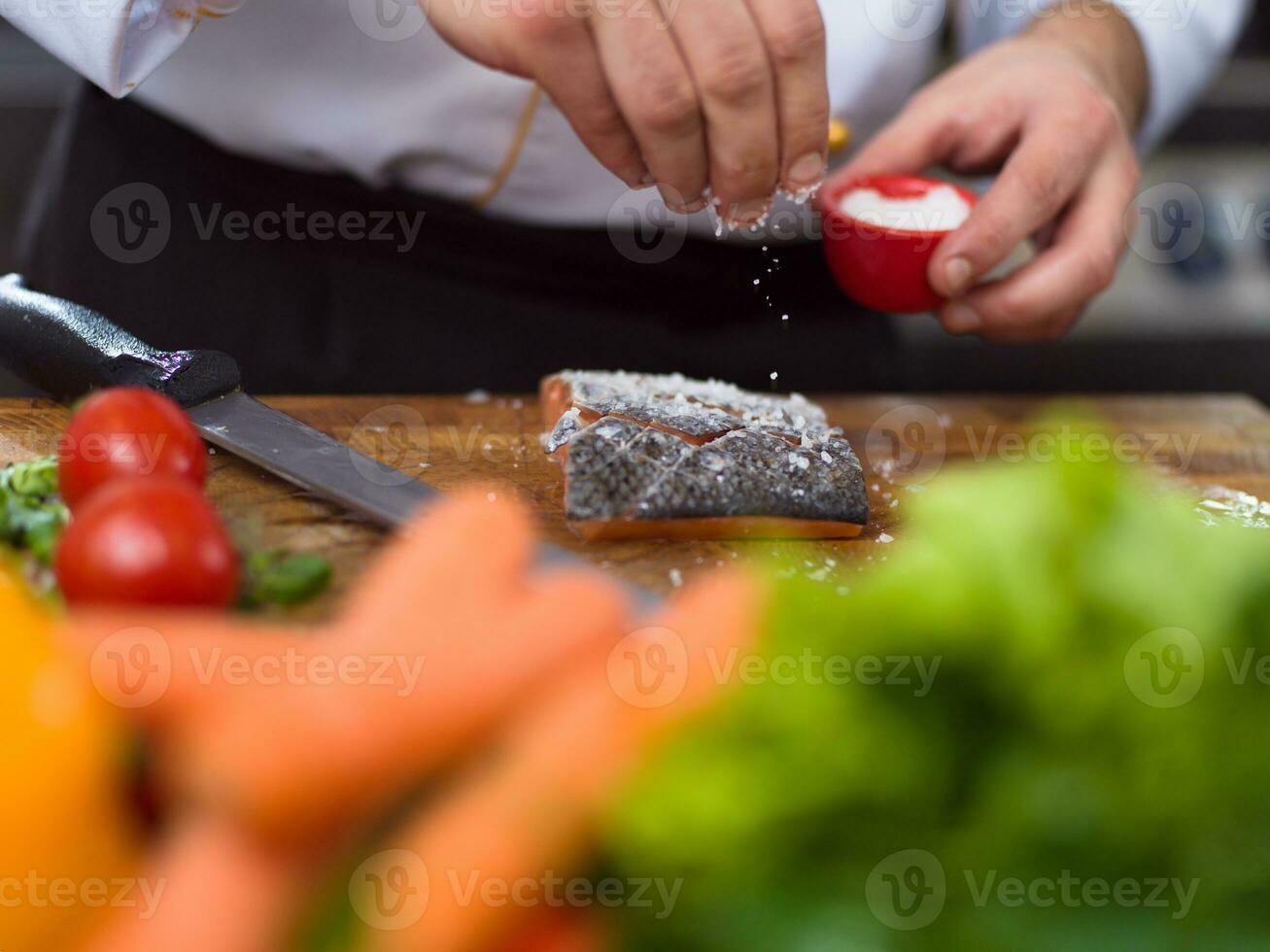 Chef hands preparing marinated Salmon fish photo