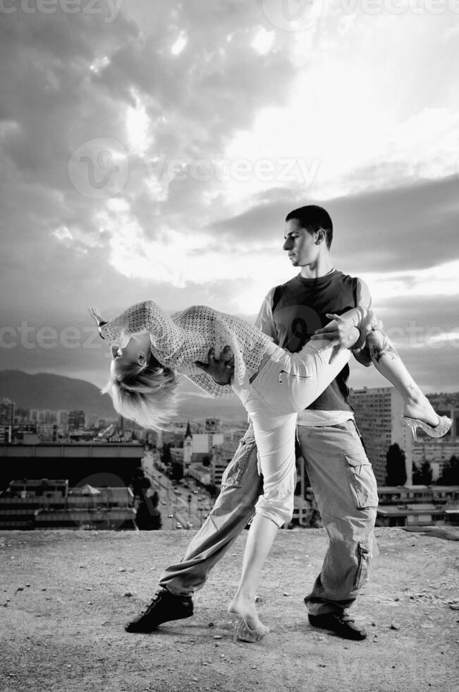 romantic urban couple dancing on top of  bulding photo