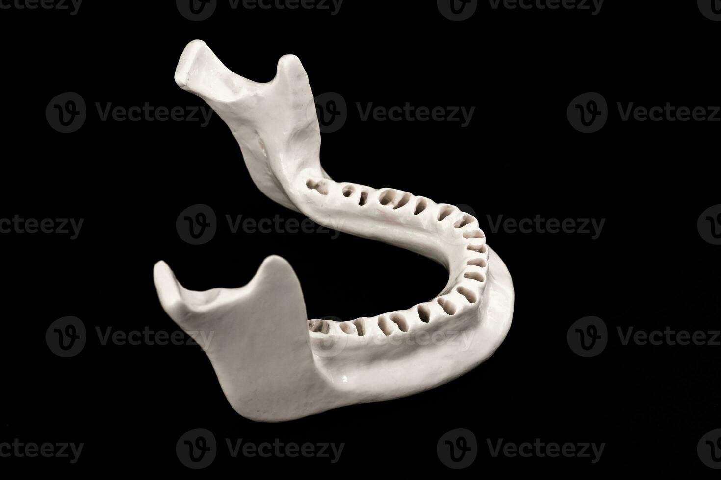 Upper human jaw without teeth model medical implant isolated on black background. Healthy teeth, dental care and orthodontic concept. photo