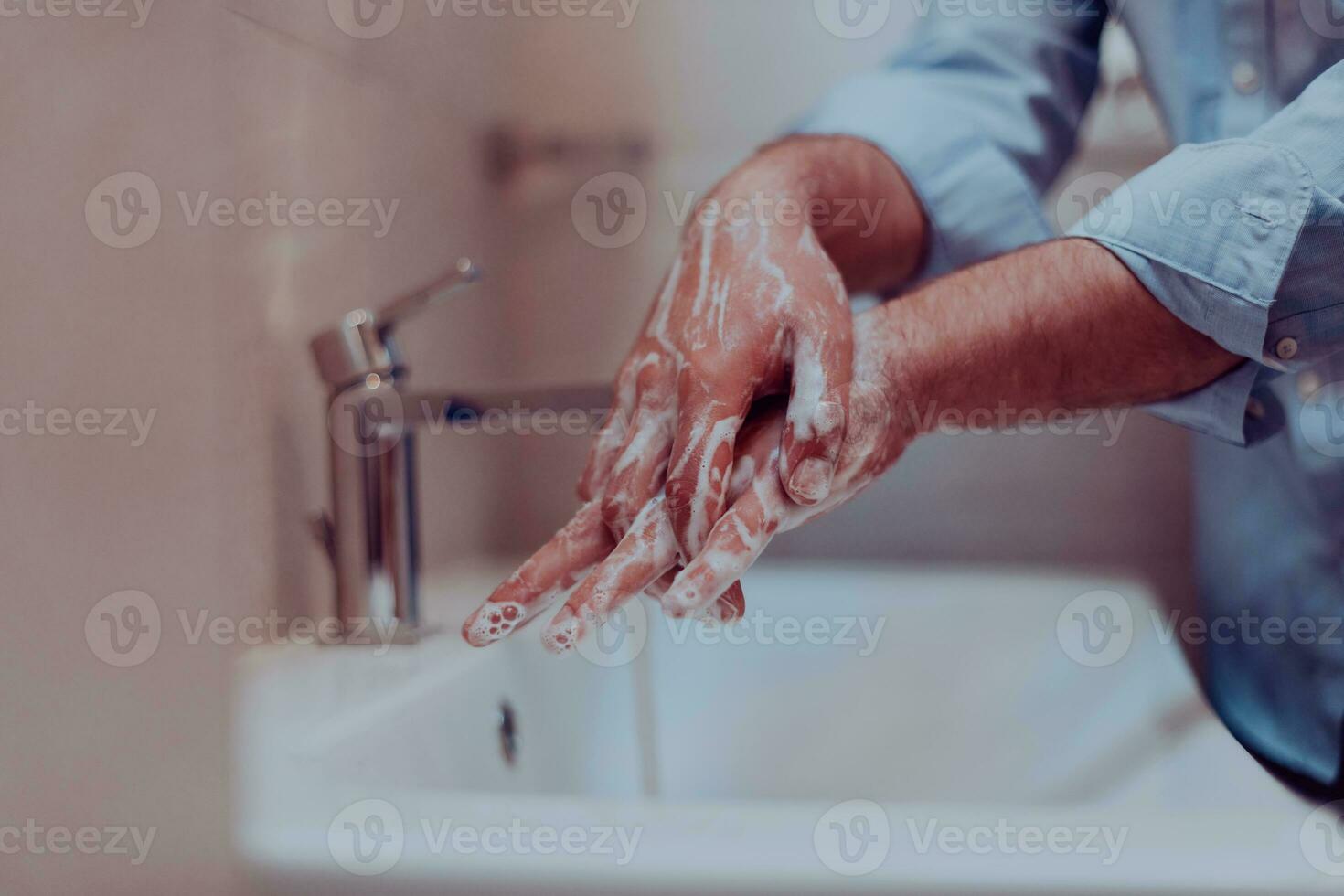 Man using soap and washing hands under the water tap. Hygiene concept hand closeup detail. photo