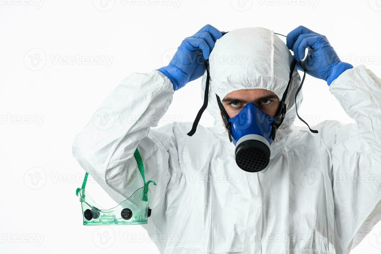 Doctor wearing protective biological suit and mask due to coronavirus 2019-nCoV global pandemic warning and danger background against white background. photo