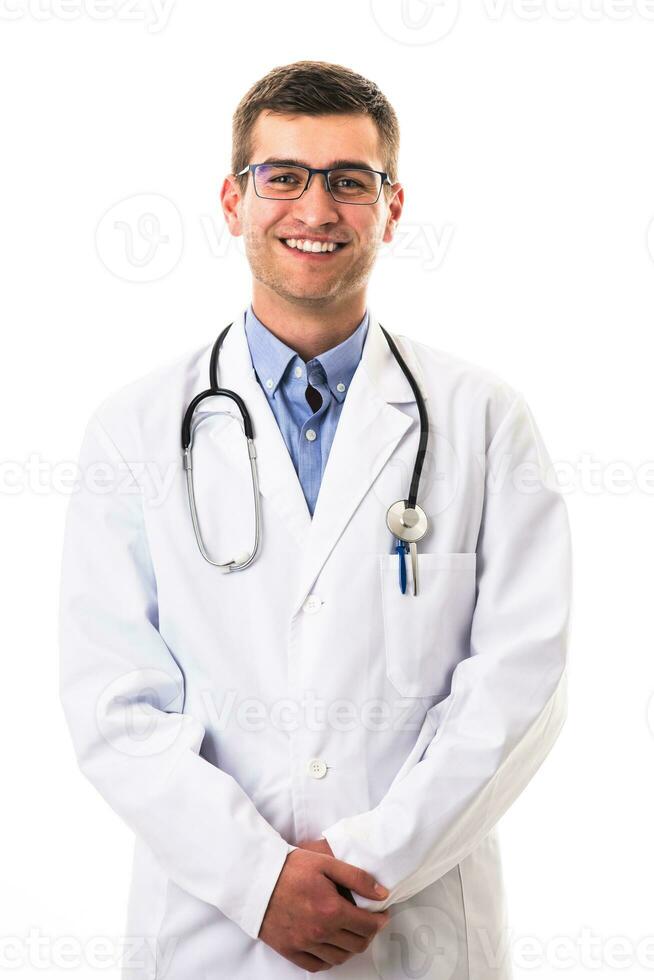 Portrait of hero in white coat. Cheerful smiling young doctor with stethoscope in medical hospital standing against white background. Coronavirus covid-19 danger alert photo