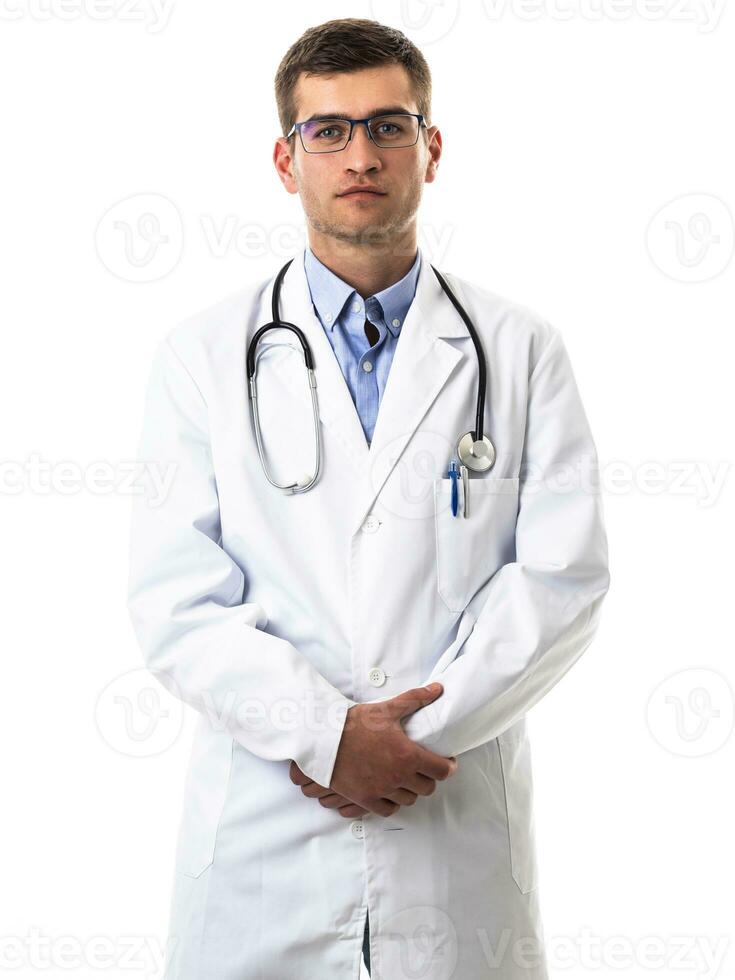 Portrait of hero in white coat. Cheerful smiling young doctor with stethoscope in medical hospital standing against white background. Coronavirus covid-19 danger alert photo