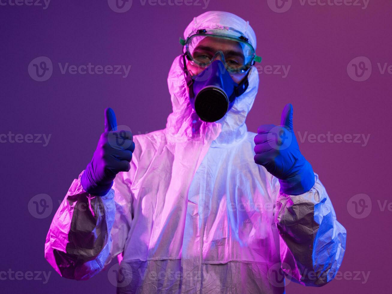 Coronavirus covid-19 pandemic. Doctor scientist wearing protective biological suit and mask due to global healthcare epidemic warning and danger background in blue and pink neon lights background. photo