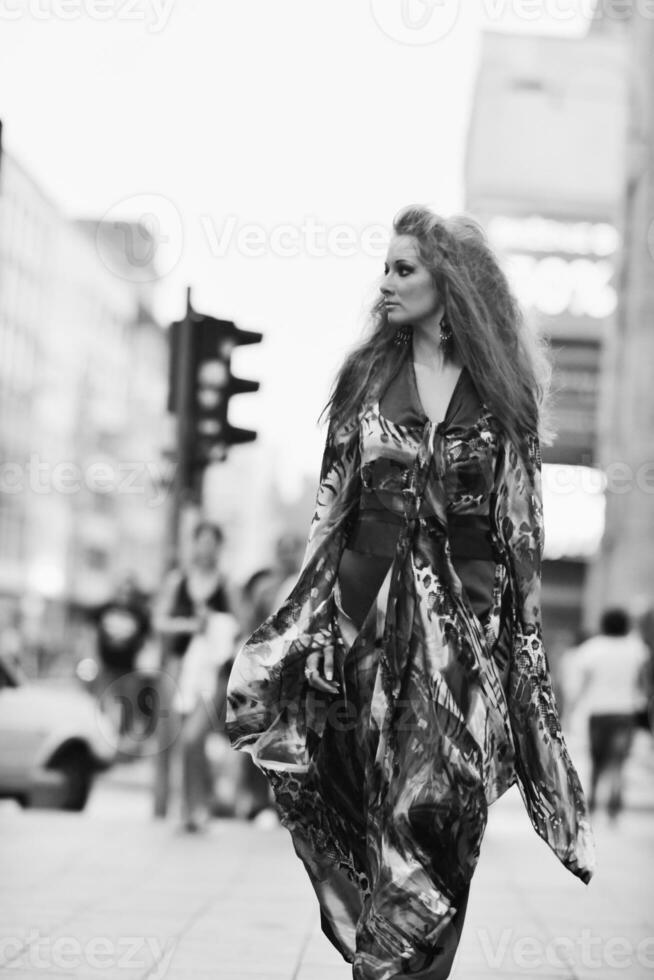 elegant woman on city street at night photo