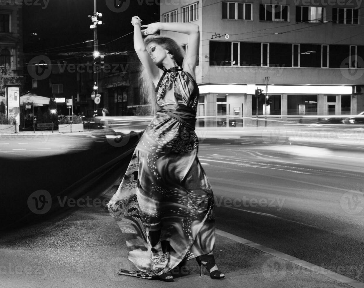 elegant woman on city street at night photo