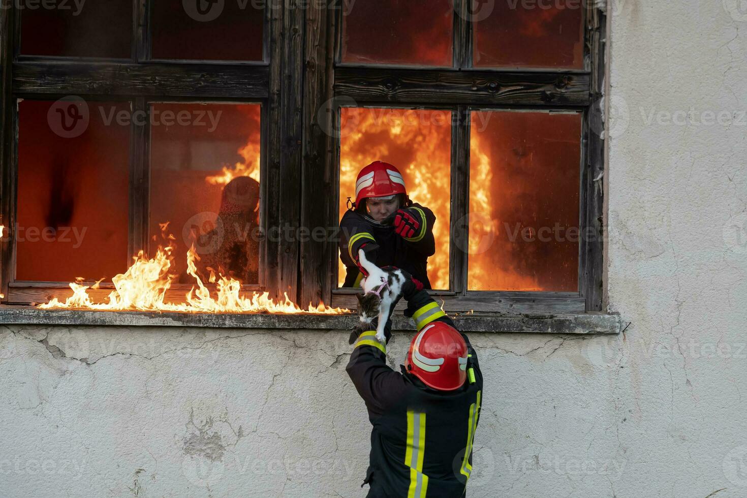 Firefighter hero carrying baby girl out from burning building area from fire incident. Rescue people from dangerous place photo