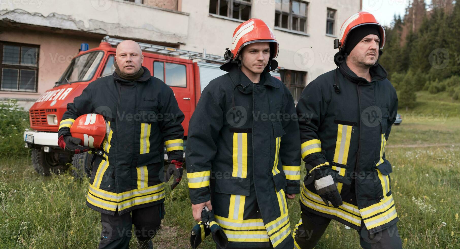 Group of fire fighters standing confident after a well done rescue operation. Firemen ready for emergency service. photo