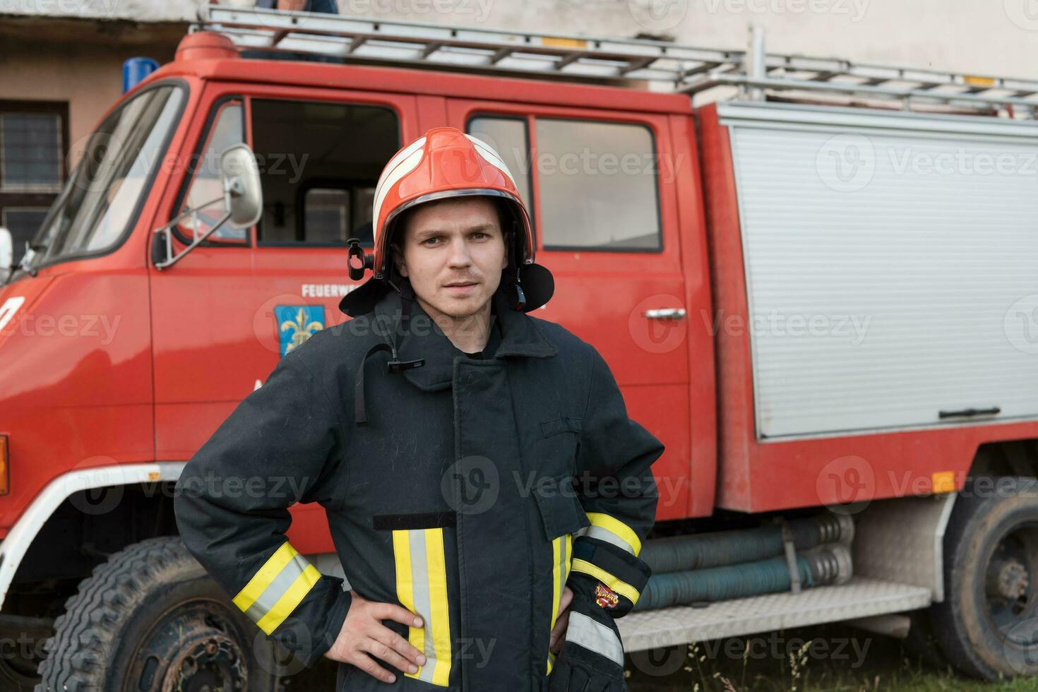 Firefighter with uniform and helmet stand in front of electric wire on a roof top photo