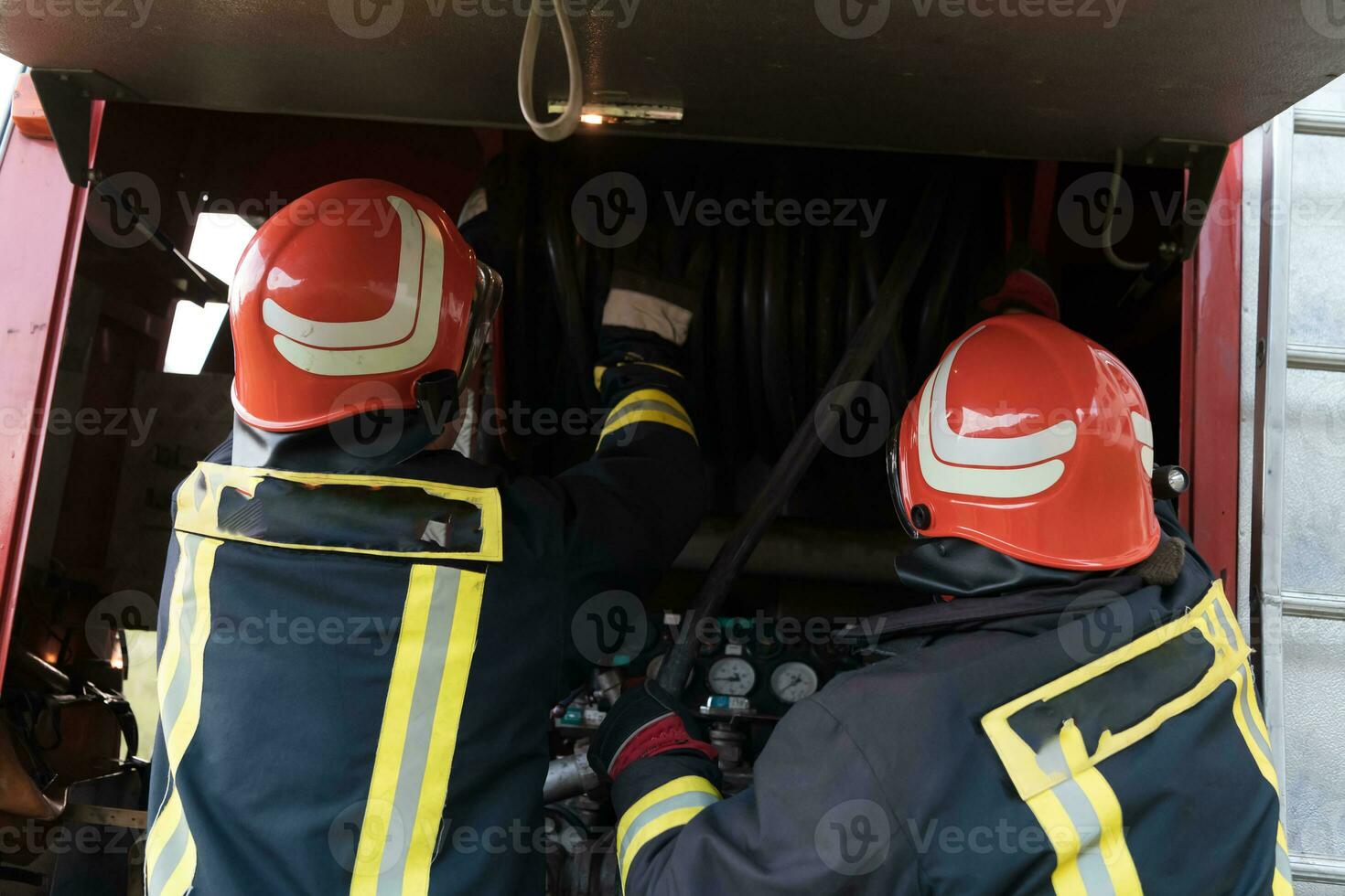 Group of fire fighters standing confident after a well done rescue operation. Firemen ready for emergency service. photo