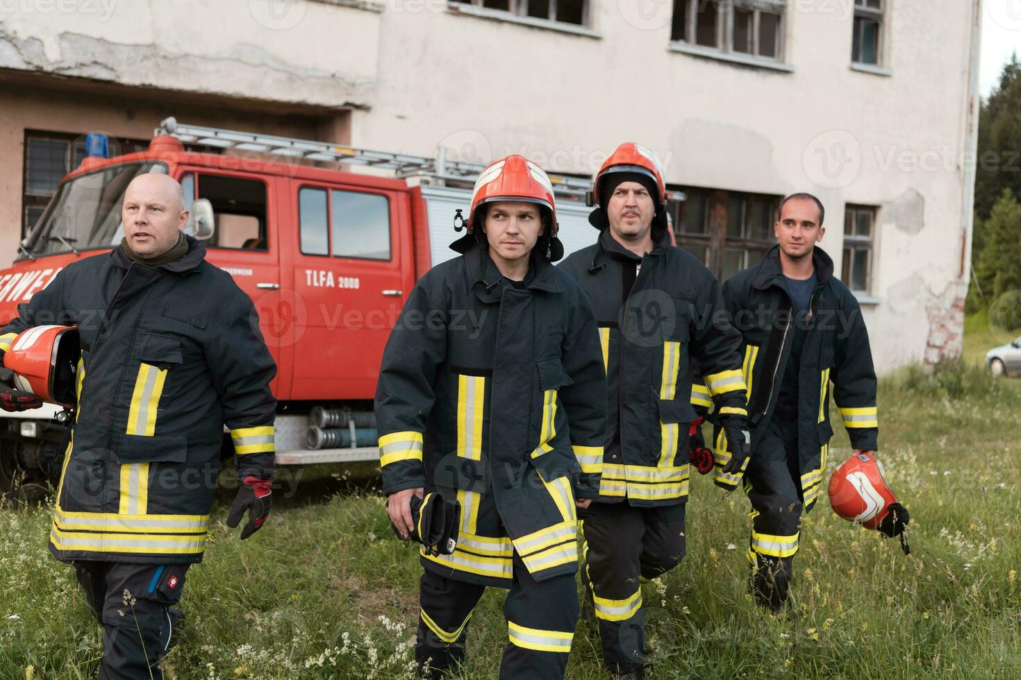 Group of fire fighters standing confident after a well done rescue operation. Firemen ready for emergency service. photo