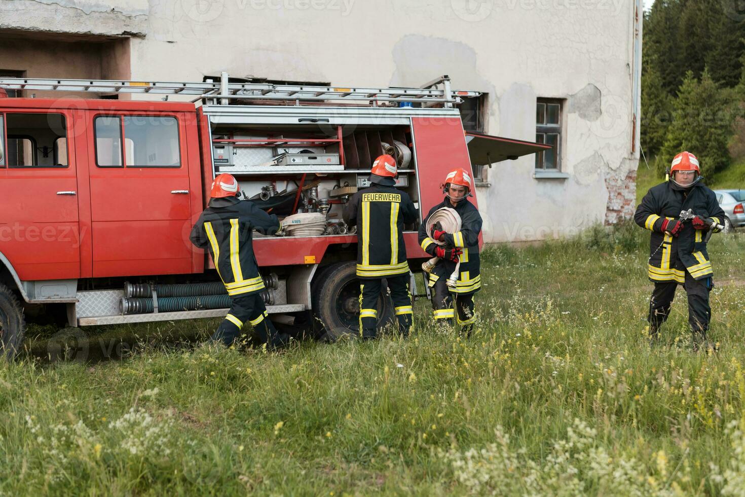 Group of fire fighters standing confident after a well done rescue operation. Firemen ready for emergency service. photo