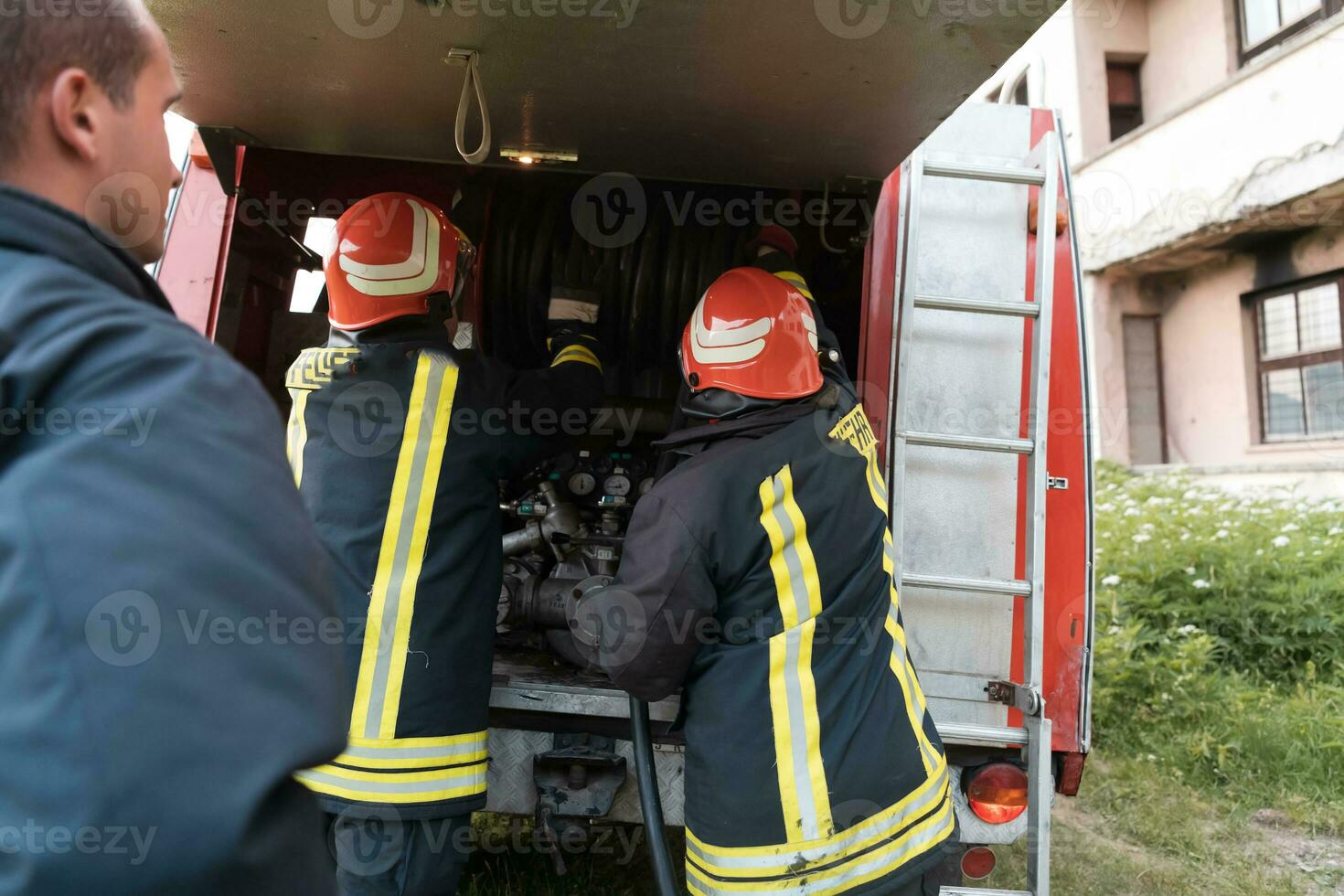 Group of fire fighters standing confident after a well done rescue operation. Firemen ready for emergency service. photo