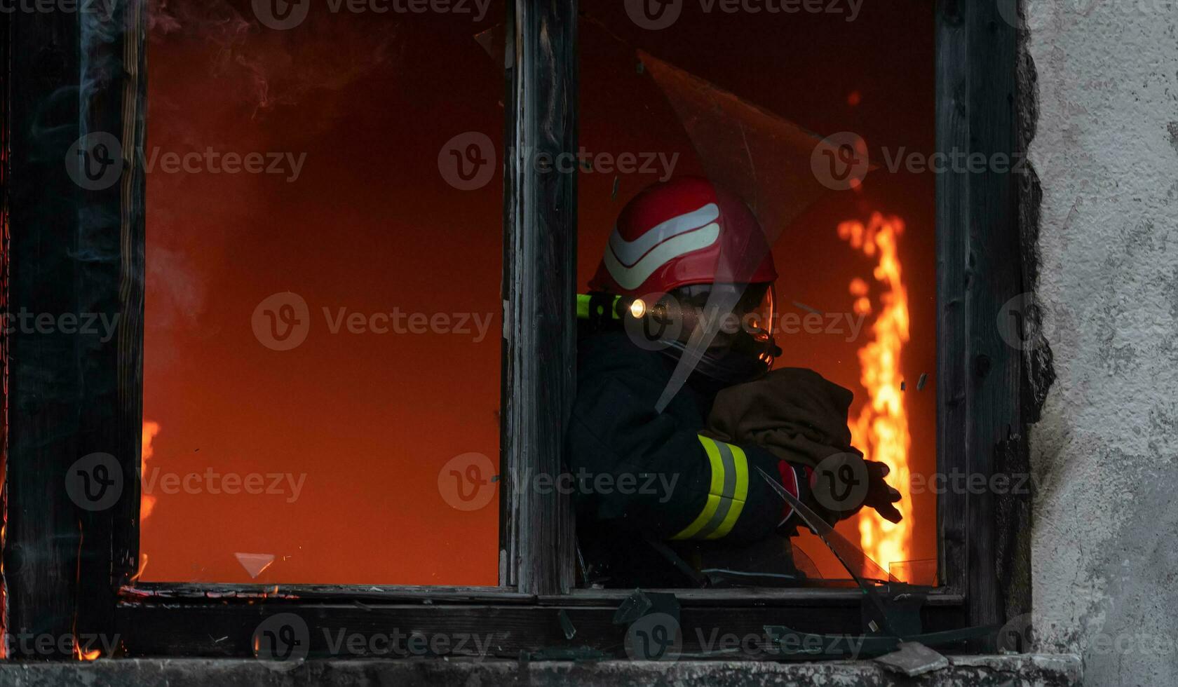 Firefighter hero carrying baby girl out from burning building area from fire incident. Rescue people from dangerous place photo