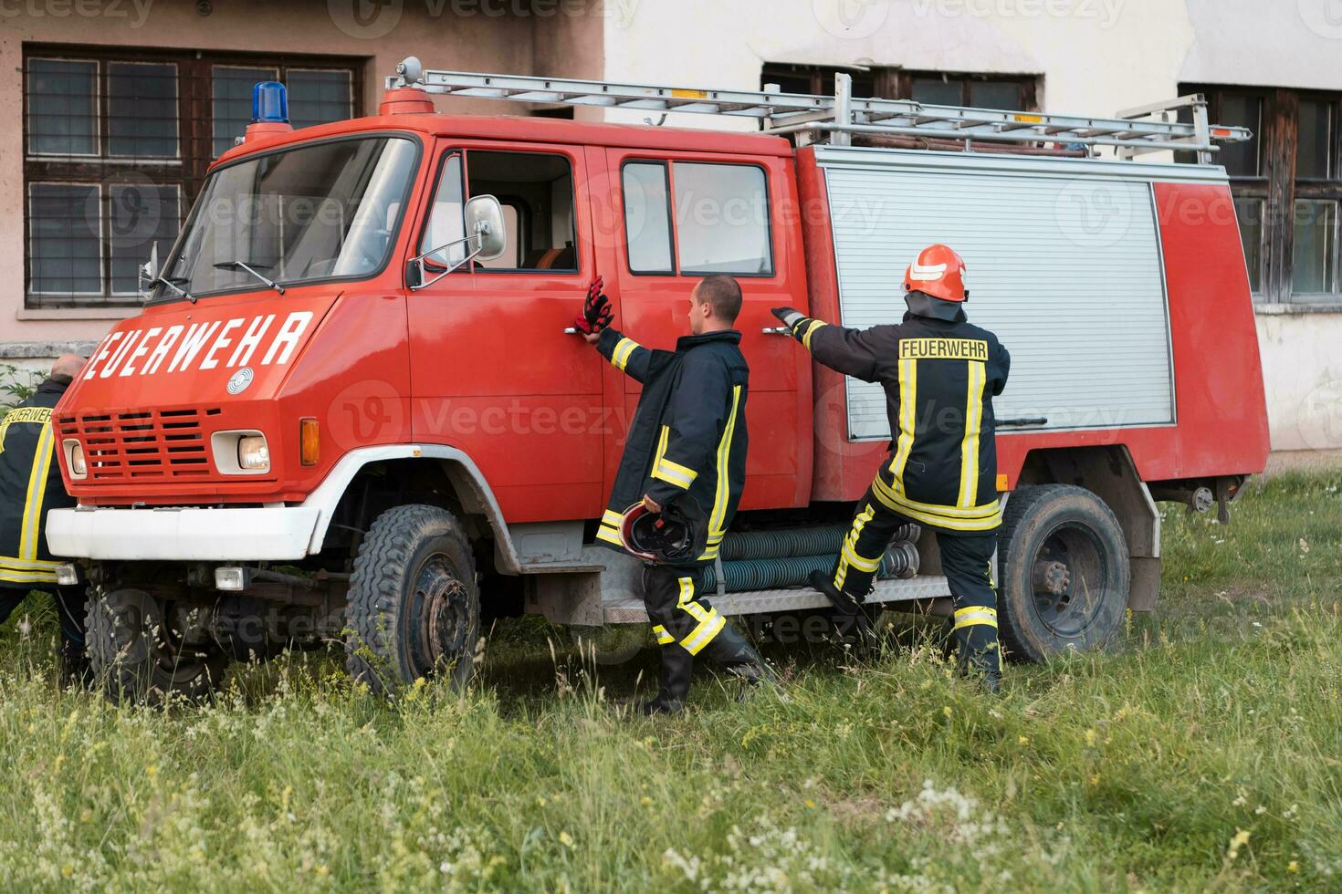 Group of fire fighters standing confident after a well done rescue operation. Firemen ready for emergency service. photo