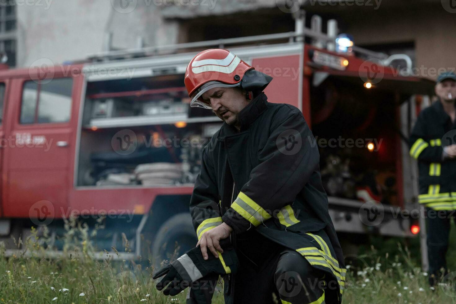 Deprimido y cansado bombero cerca fuego camión. foto