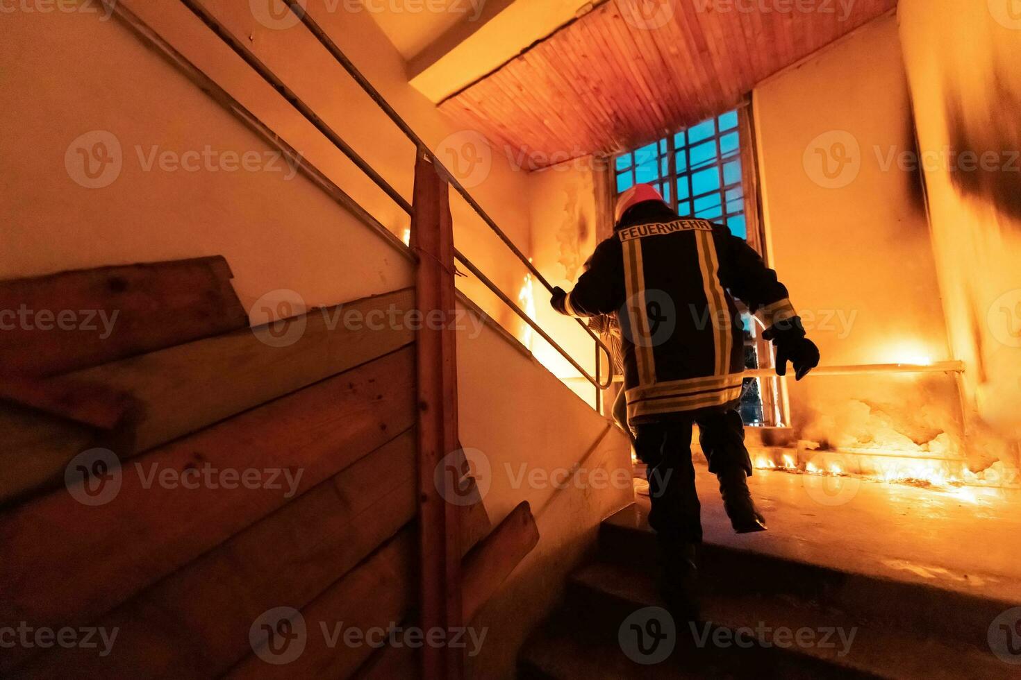 Brave Fireman going upstairs to save and rescue people in a Burning Building. Open fire and flame. photo