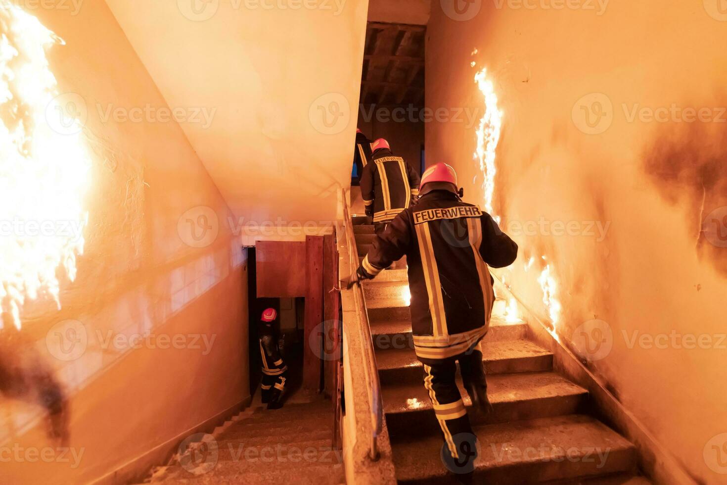 Brave Fireman going upstairs to save and rescue people in a Burning Building. Open fire and flame. photo