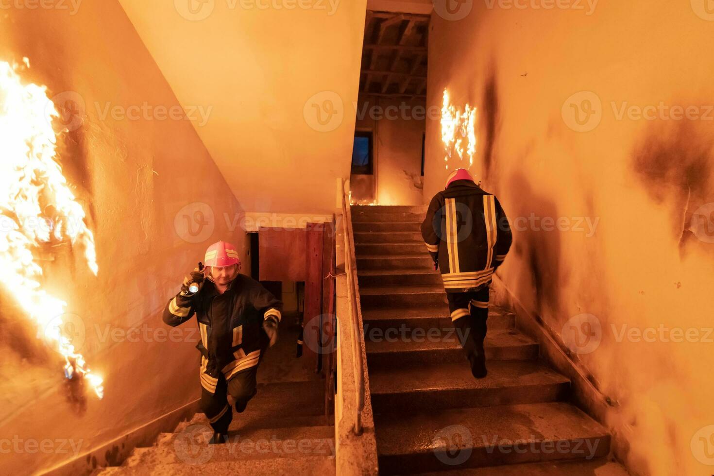 Brave Fireman going upstairs to save and rescue people in a Burning Building. Open fire and flame. photo