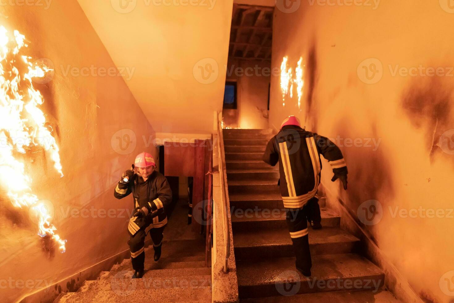 Brave Fireman going upstairs to save and rescue people in a Burning Building. Open fire and flame. photo