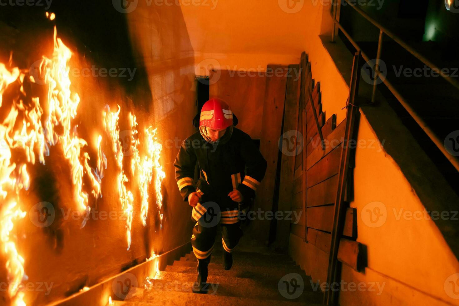 Brave Fireman going upstairs to save and rescue people in a Burning Building. Open fire and flame. photo