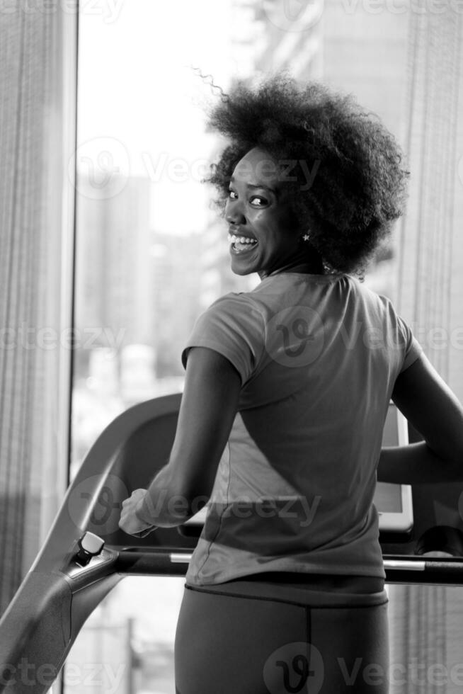 afro american woman running on a treadmill photo