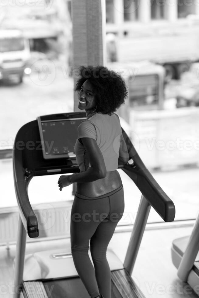 mujer afroamericana corriendo en una caminadora foto