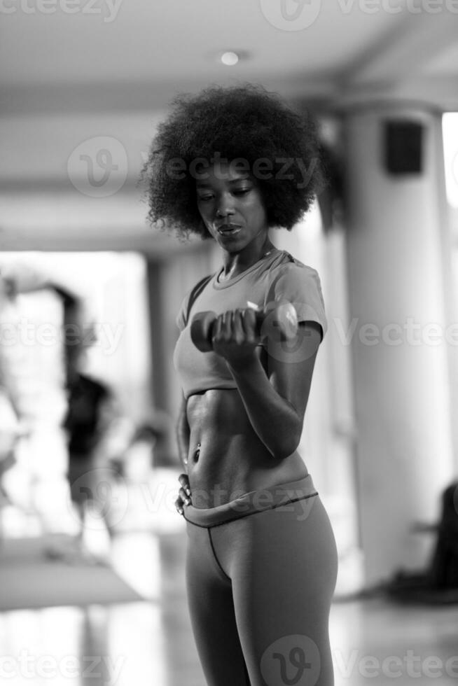 mujer haciendo ejercicio en un gimnasio crossfit con pesas foto