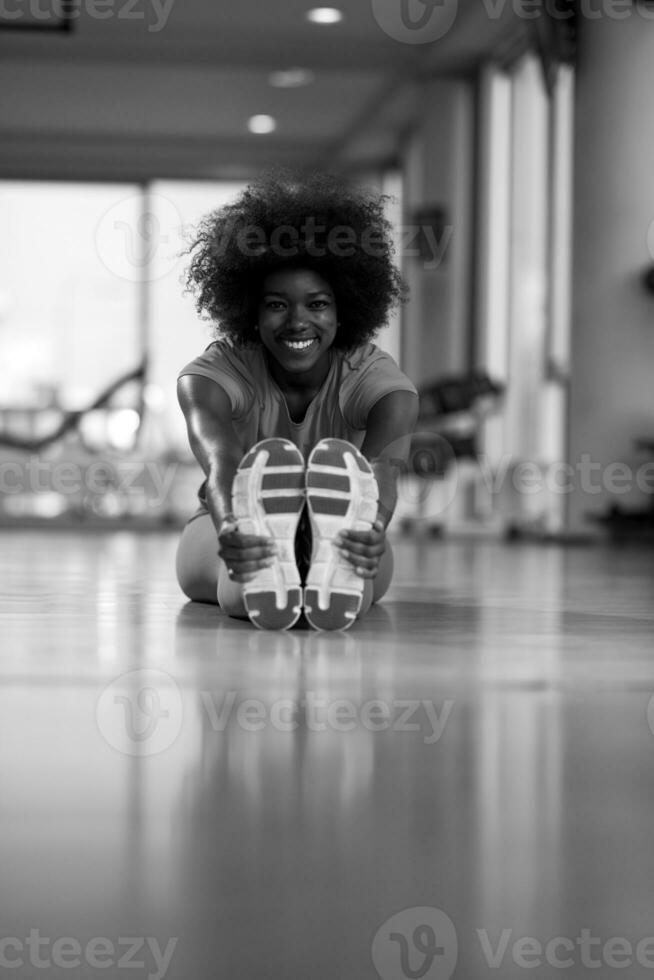 woman in a gym stretching and warming up before workout photo