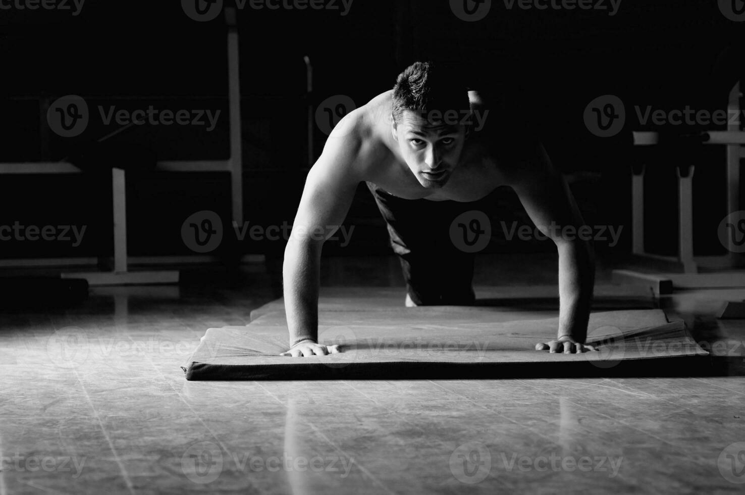 joven con brazos fuertes haciendo ejercicio en el gimnasio foto