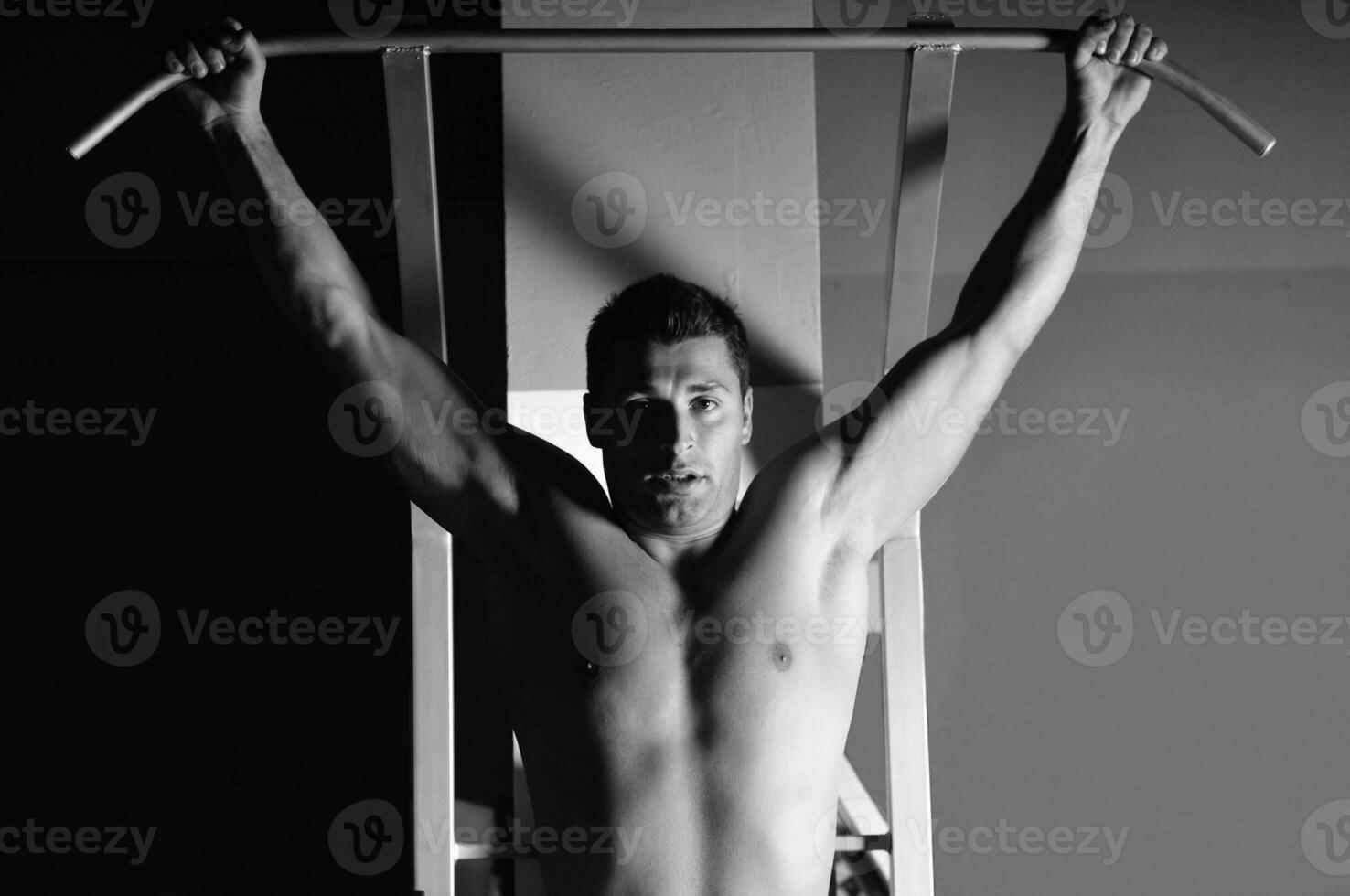 young man with strong arms working out in gym photo