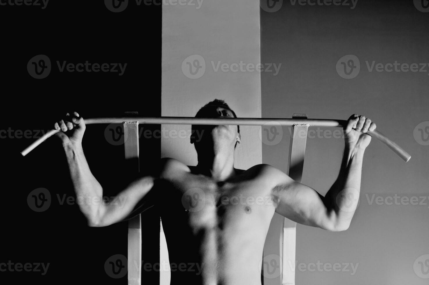 joven con brazos fuertes haciendo ejercicio en el gimnasio foto