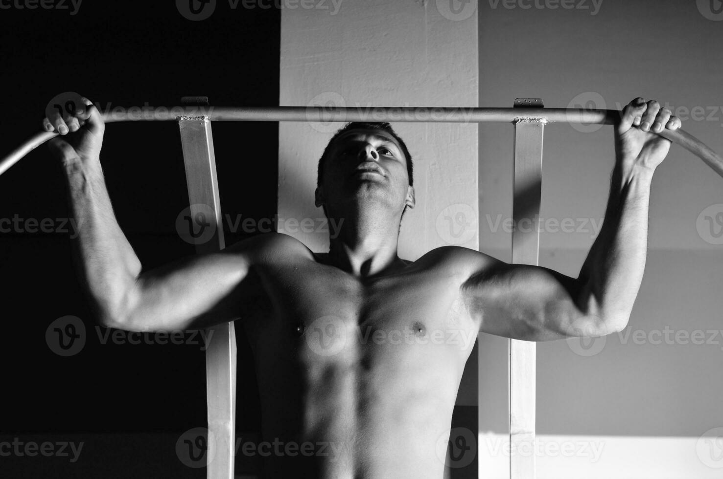 young man with strong arms working out in gym photo