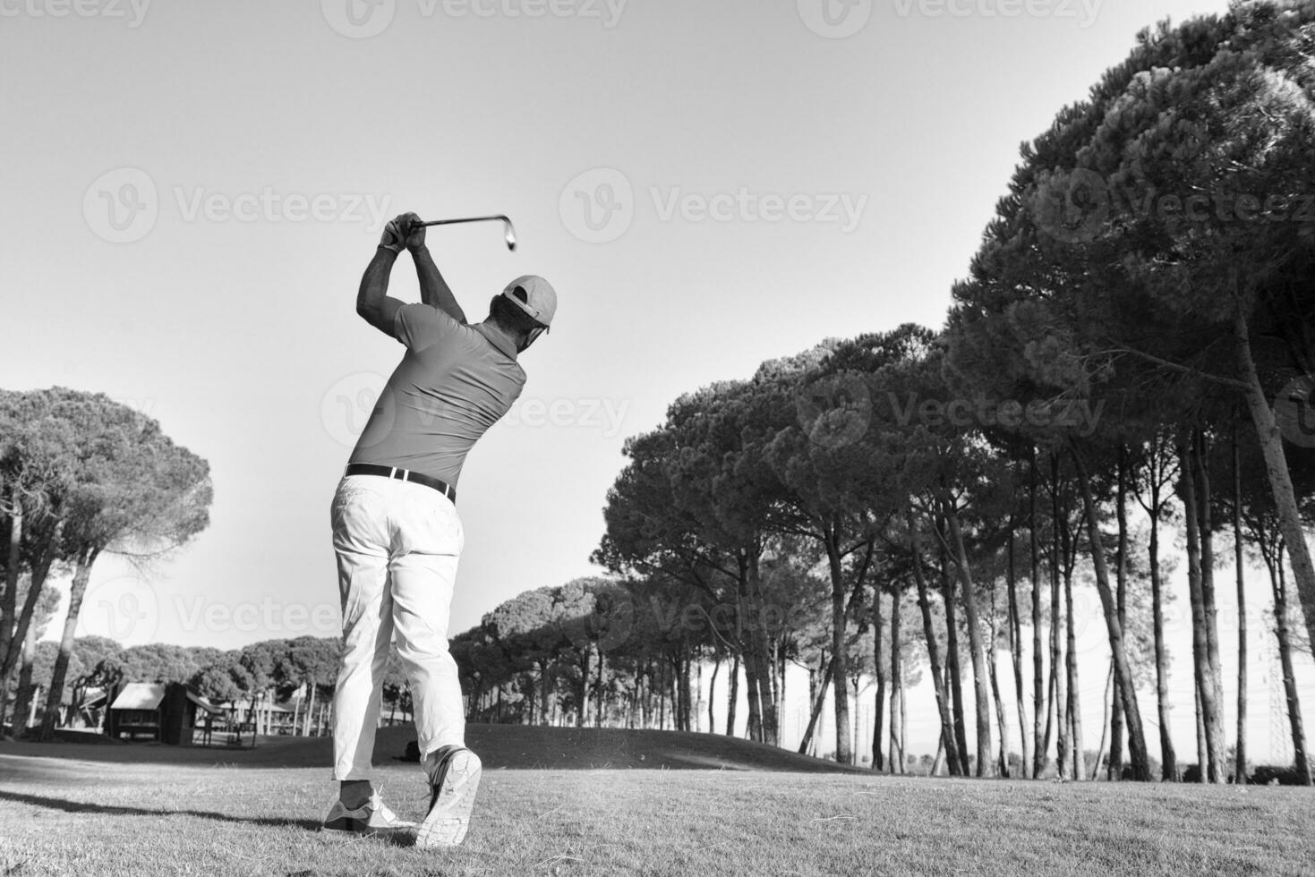golf player hitting shot with club photo