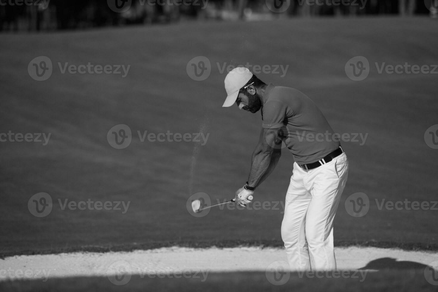 golfer hitting a sand bunker shot photo