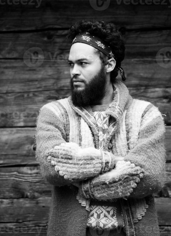 portrait of young hipster in front of wooden house photo