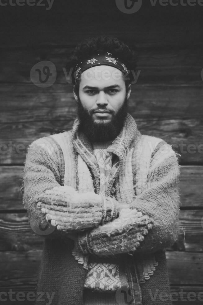 portrait of young hipster in front of wooden house photo