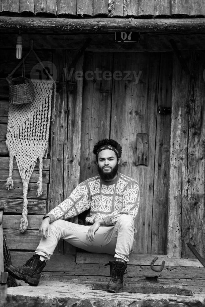 retrato de joven hipster frente a casa de madera foto