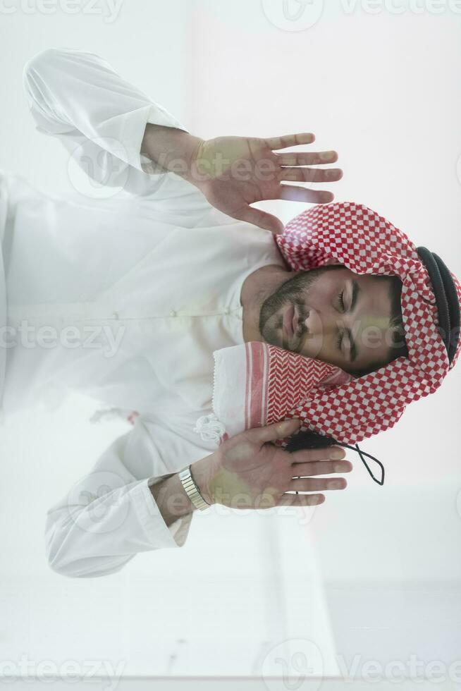 Muslim man doing sujud or sajdah on the glass floor photo