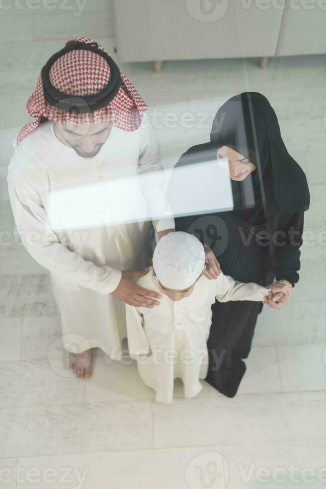 Portrait of a young happy Arabian Muslim family couple with a son in traditional clothes spending time together photo