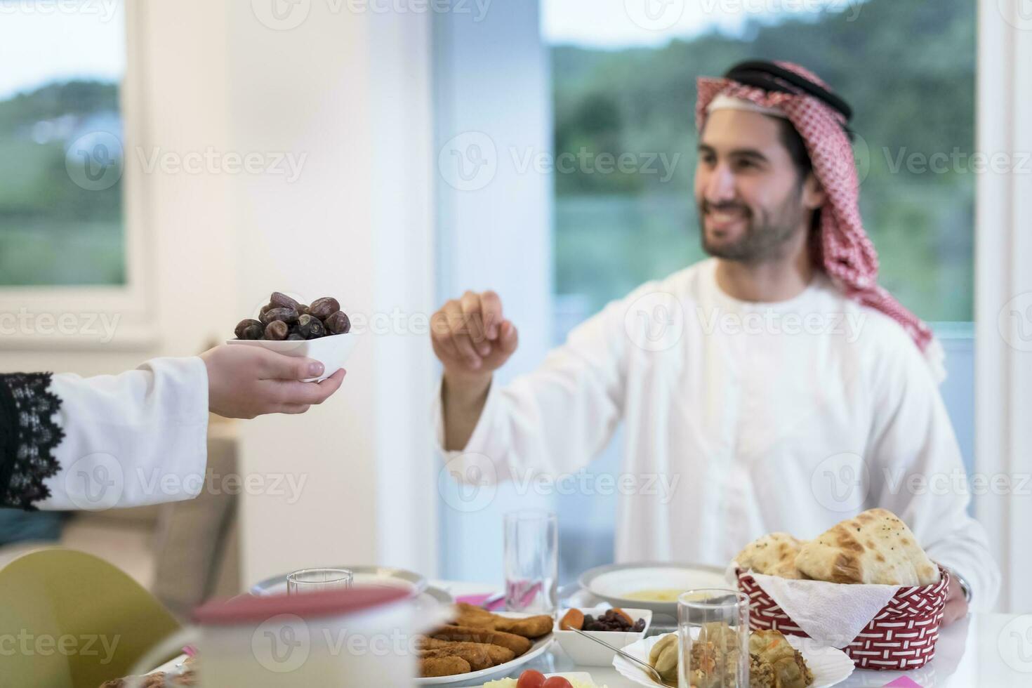 modern multiethnic muslim family sharing a bowl of dates while enjoying iftar dinner together during a ramadan feast at home photo