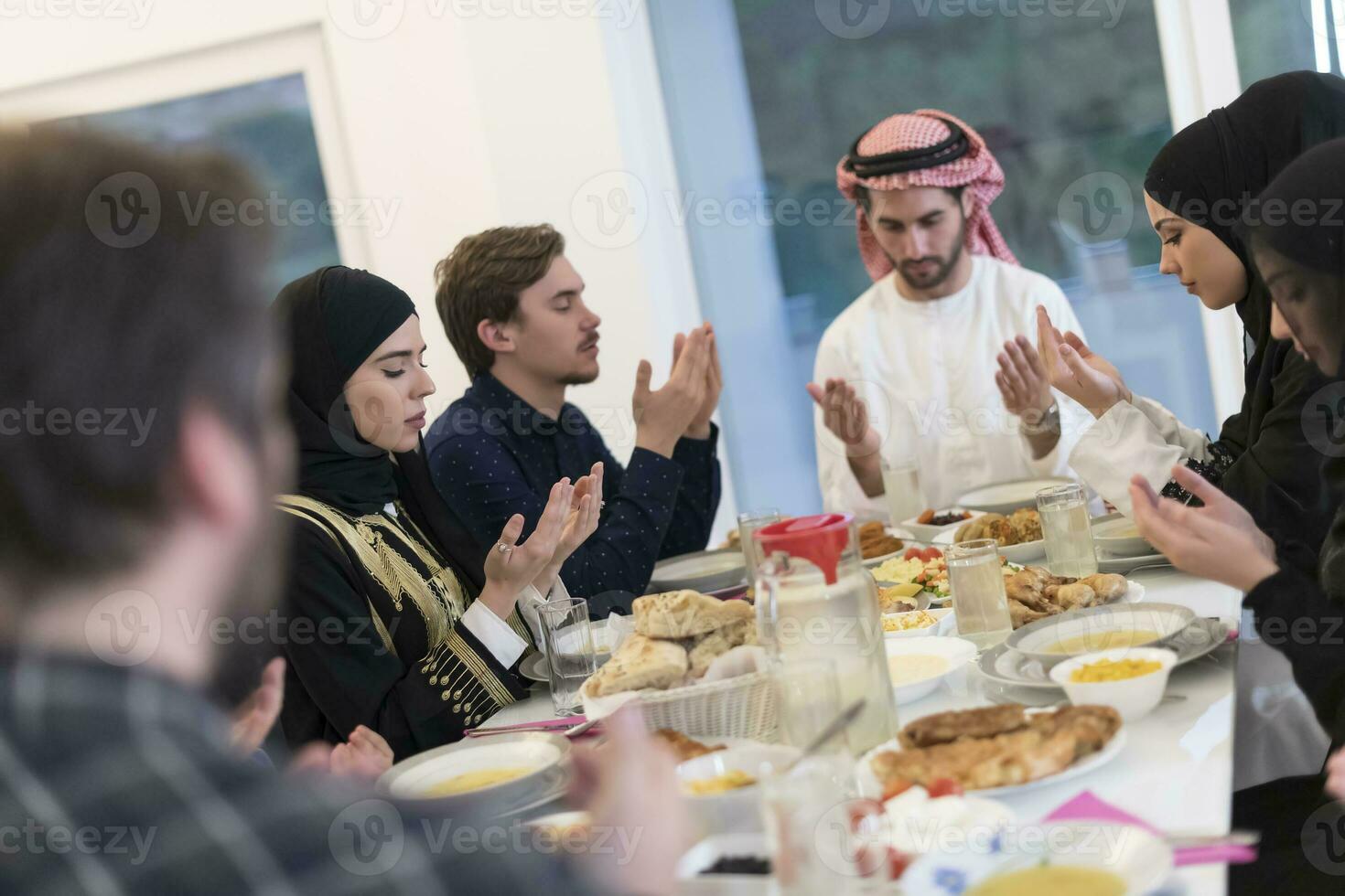 Muslim family making iftar dua to break fasting during Ramadan. photo